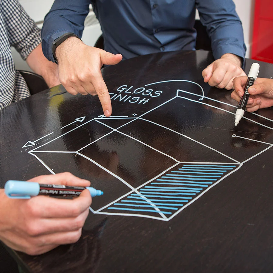 Employes utilisent marqueurs sur table avec peinture tableau blanc transparente
